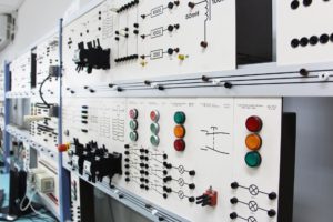 Oblique angle view of a line of control panels and circuit boards in an electronic laboratory interior